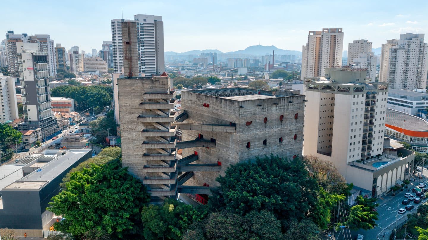 Vista aérea do Sesc Pompeia, com as torres de concreto e as passarelas entre árvores
